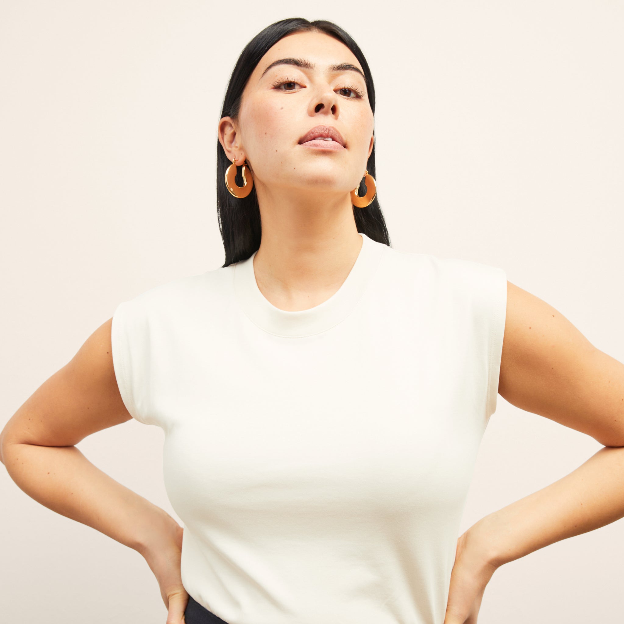 Front image of a woman standing wearing the alina top in compact cotton in ivory 