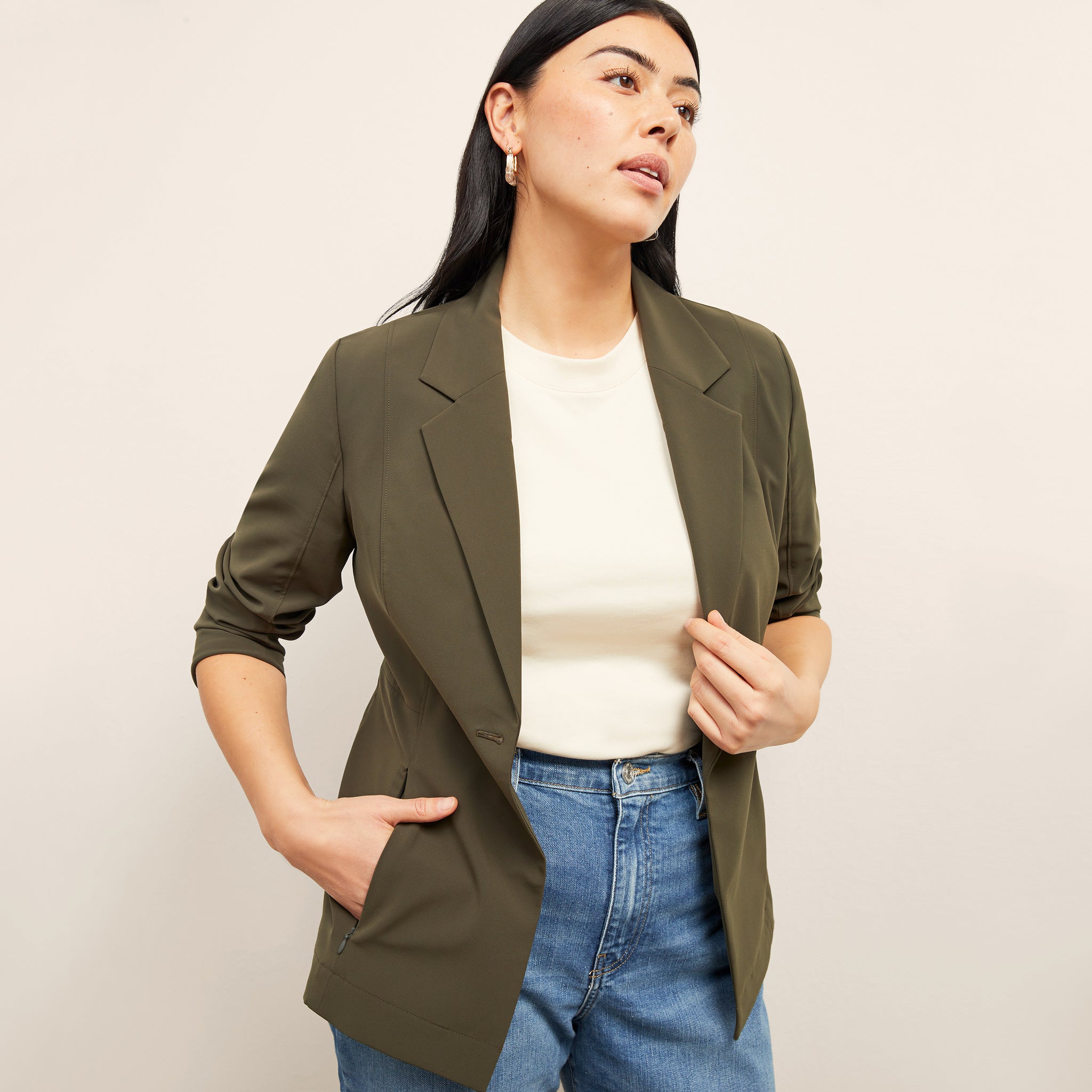 Front image of a woman standing wearing the Moreland jacket in olive 