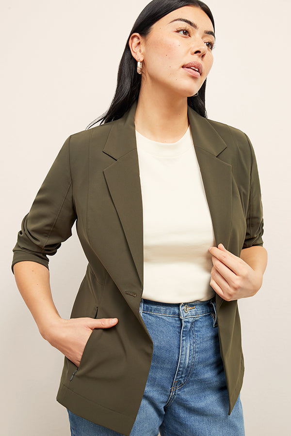 Front image of a woman standing wearing the Moreland jacket in olive 