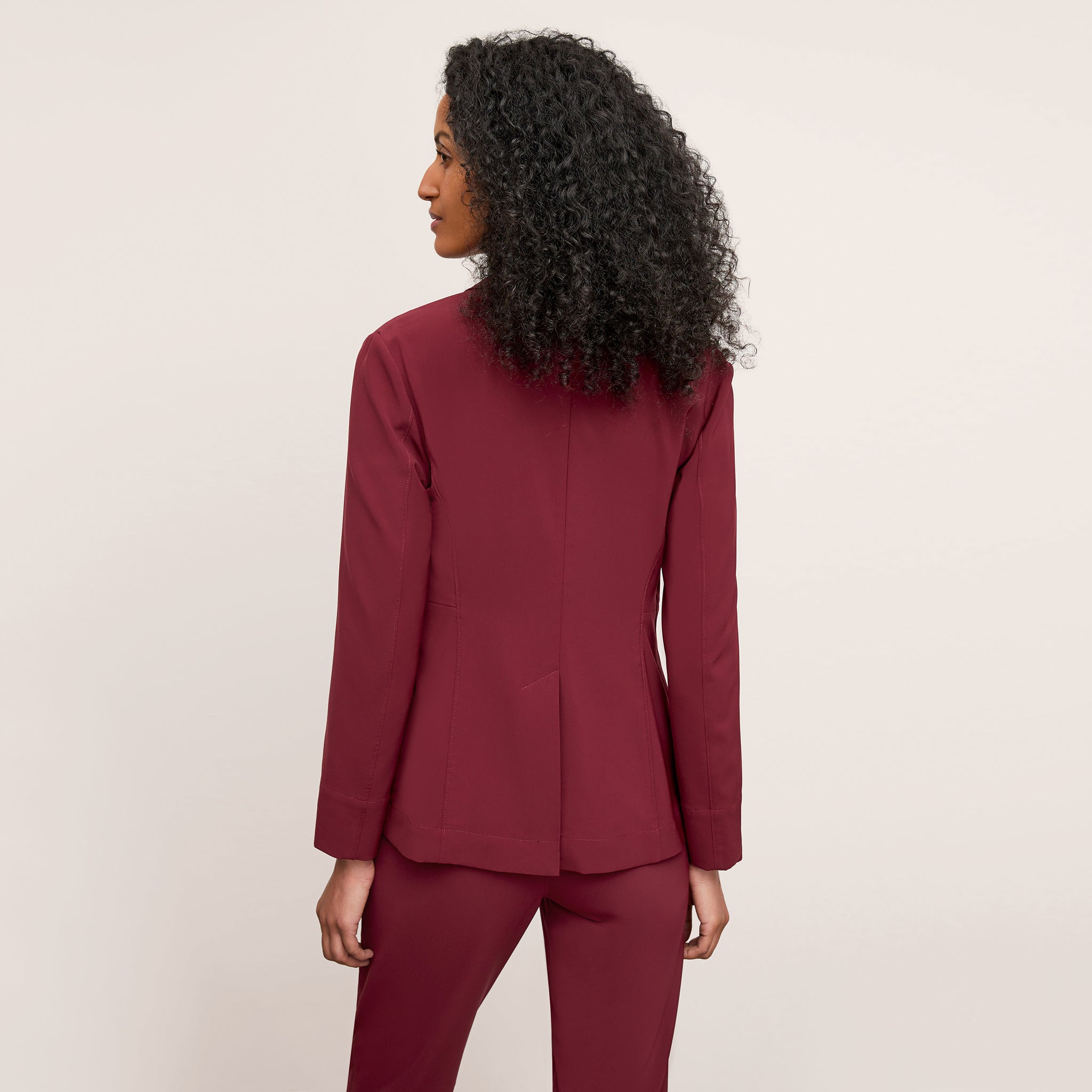 back image of a woman wearing the moreland jacket in berry jam