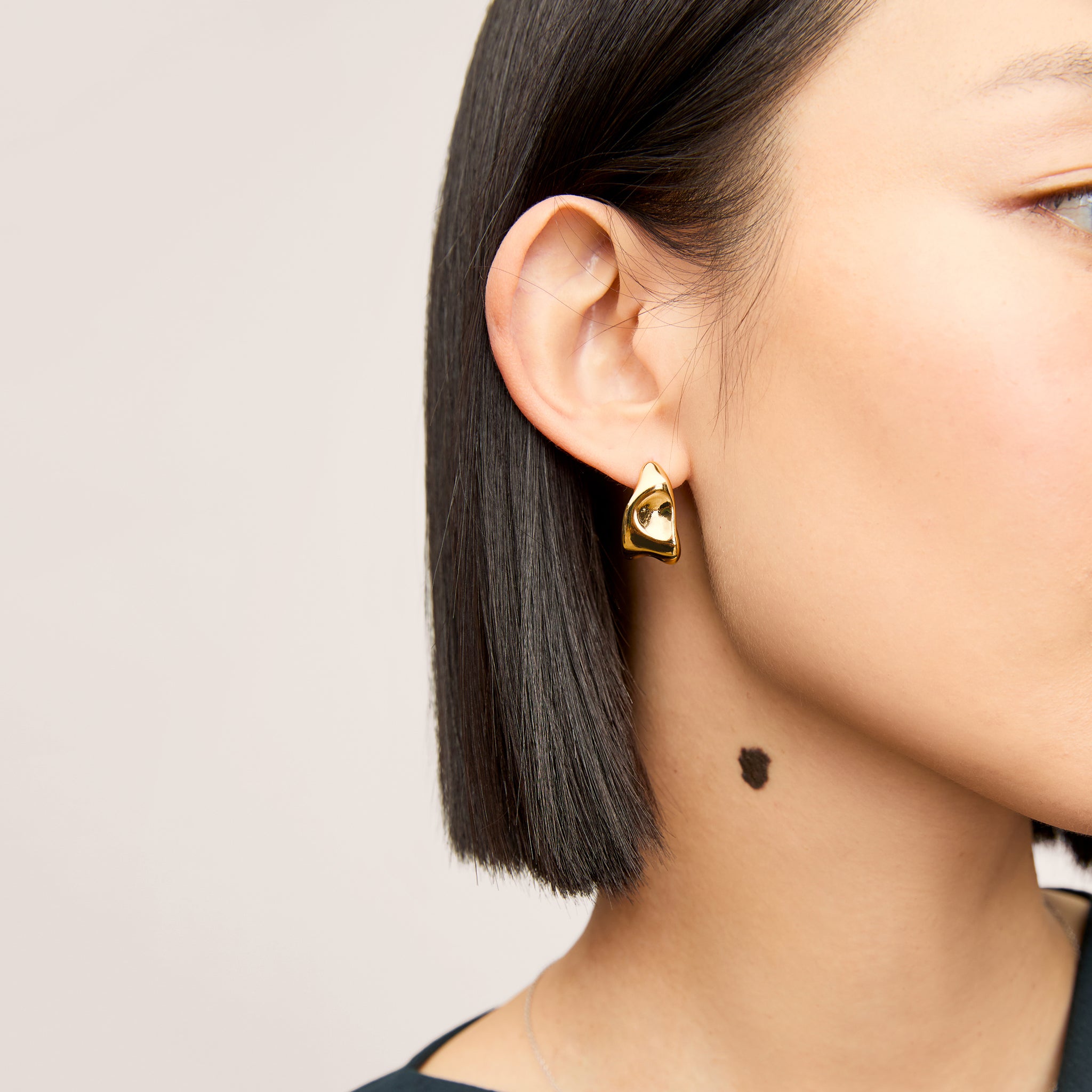 image of a woman wearing the lewis earrings in gold