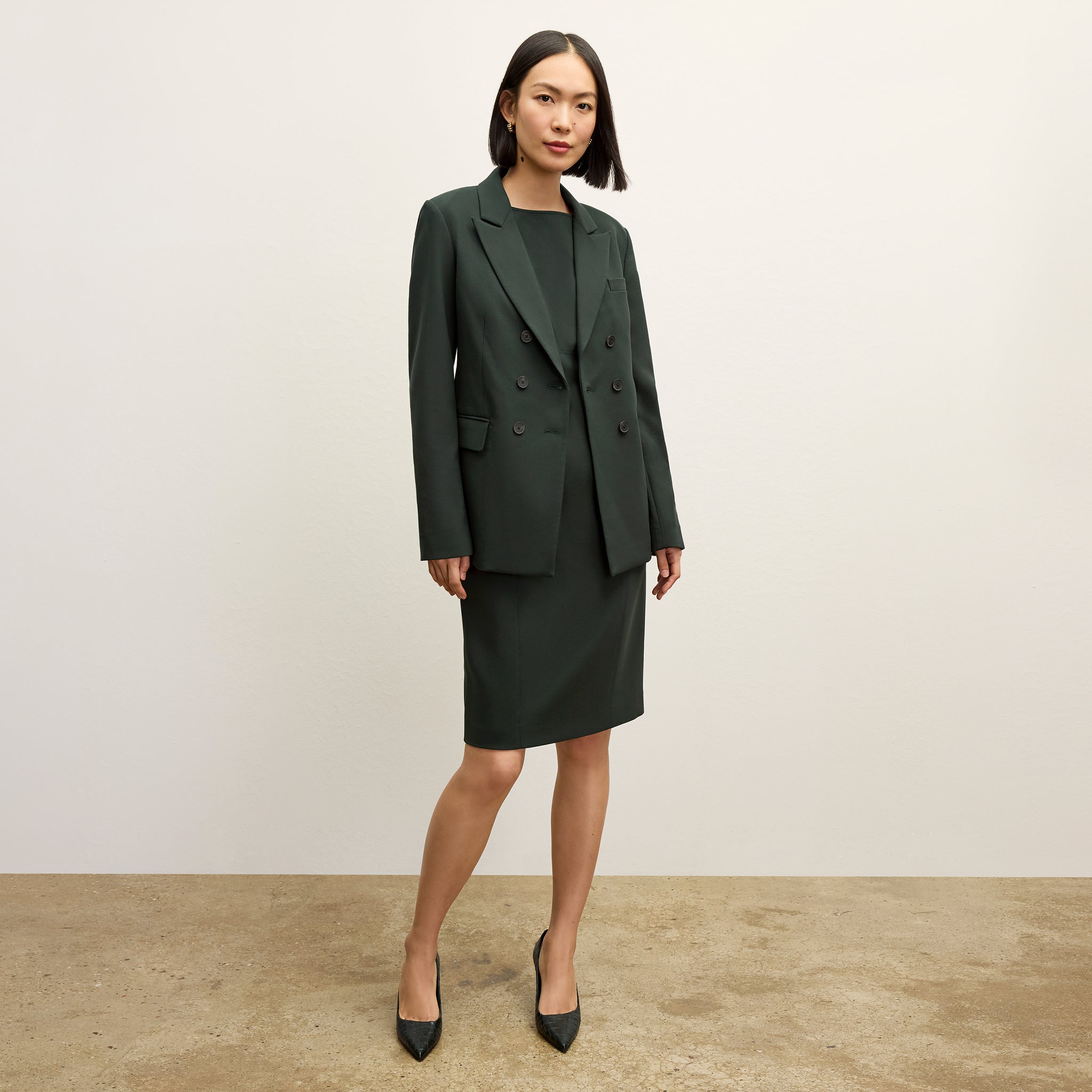 front image of a woman wearing the winston dress in dark emerald 