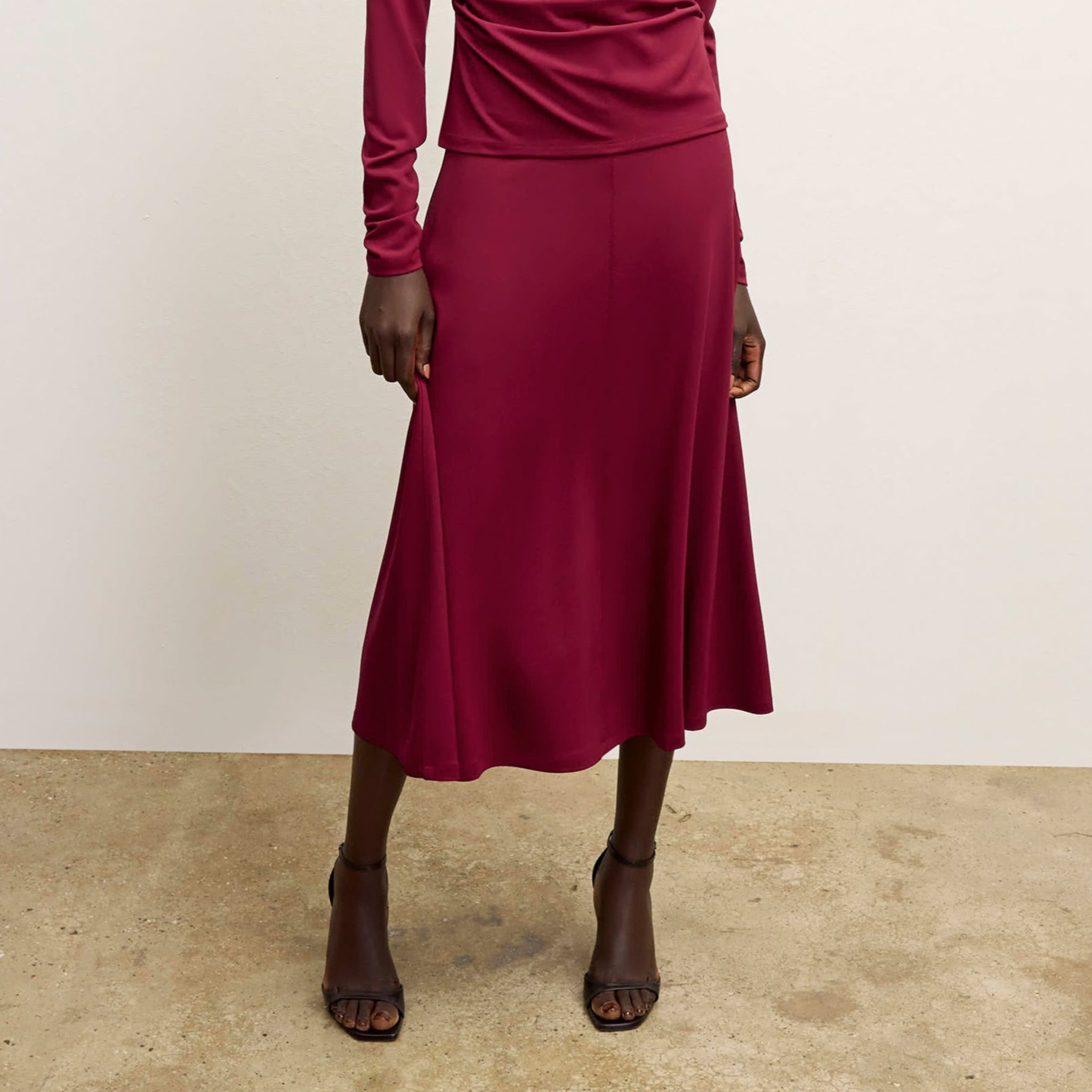 front image of a woman wearing the misty skirt in grenache 