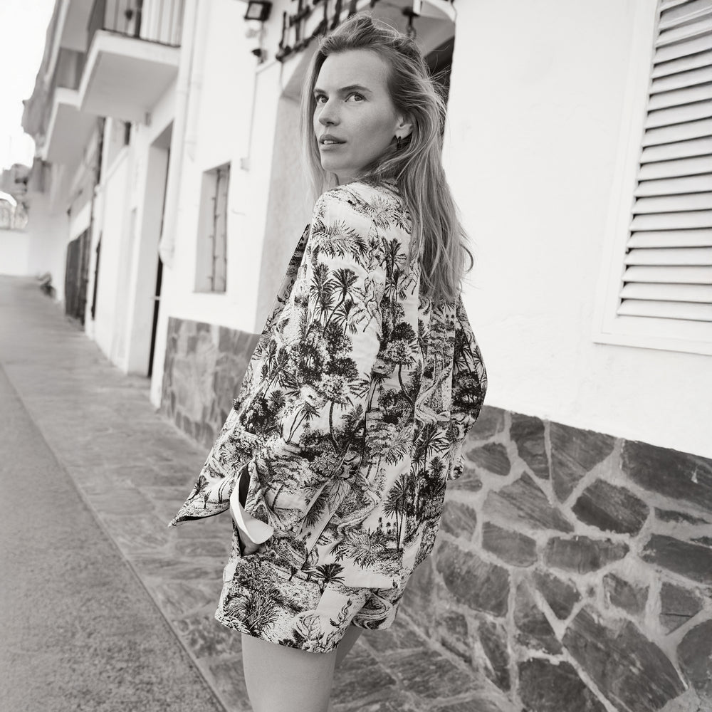 Woman wearing a floral kimono-style garment on a street.