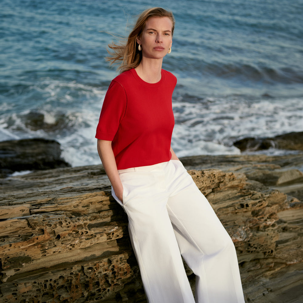 Women in red shirts and white jeans on the beach
