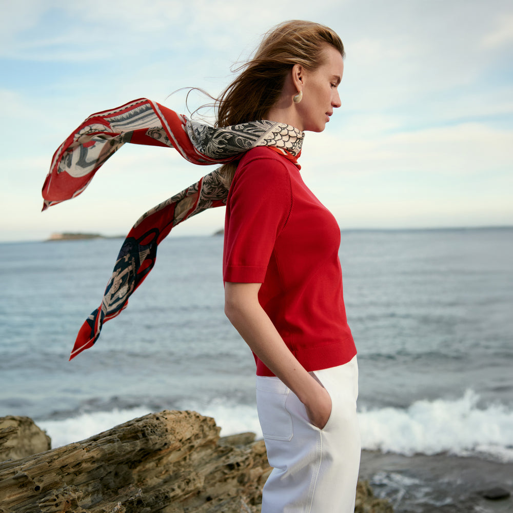 Women in red shirt and white jeans on the beach