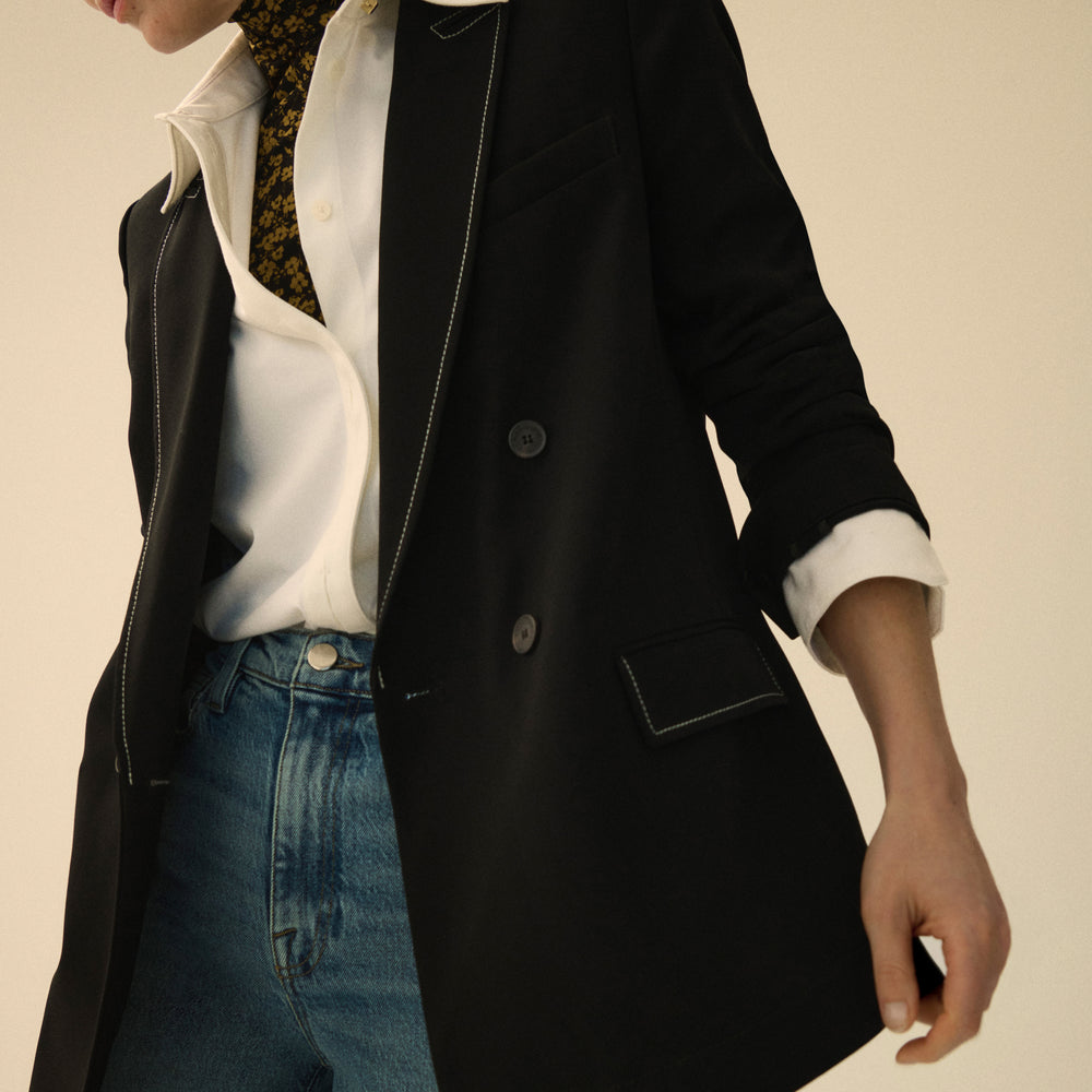 front image of a woman wearing the o'hara jacket in black with topstitch