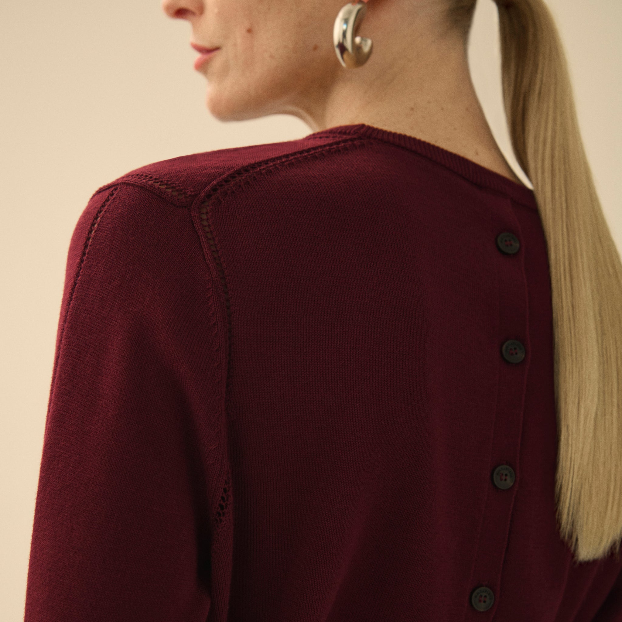 back image of a woman wearing the larissa sweater in syrah 