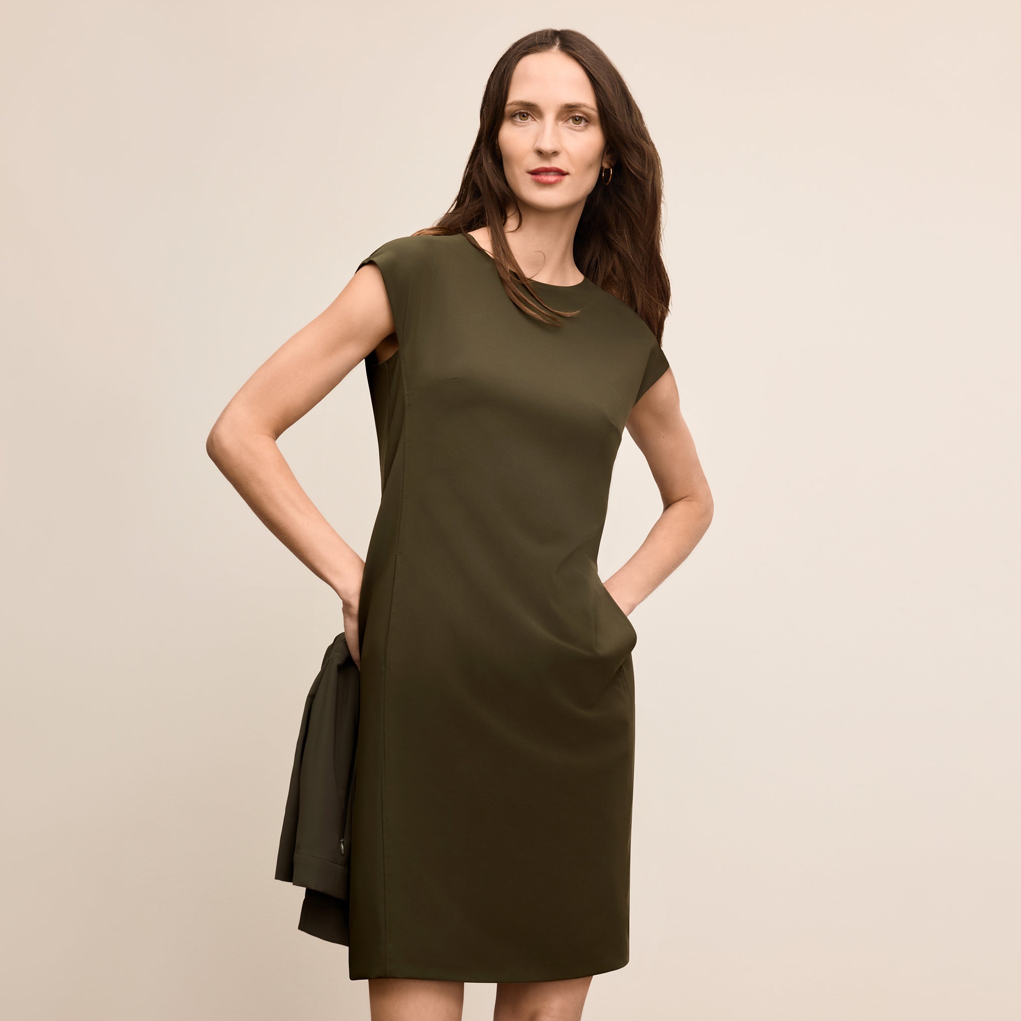 Woman wearing a green dress against a beige background 