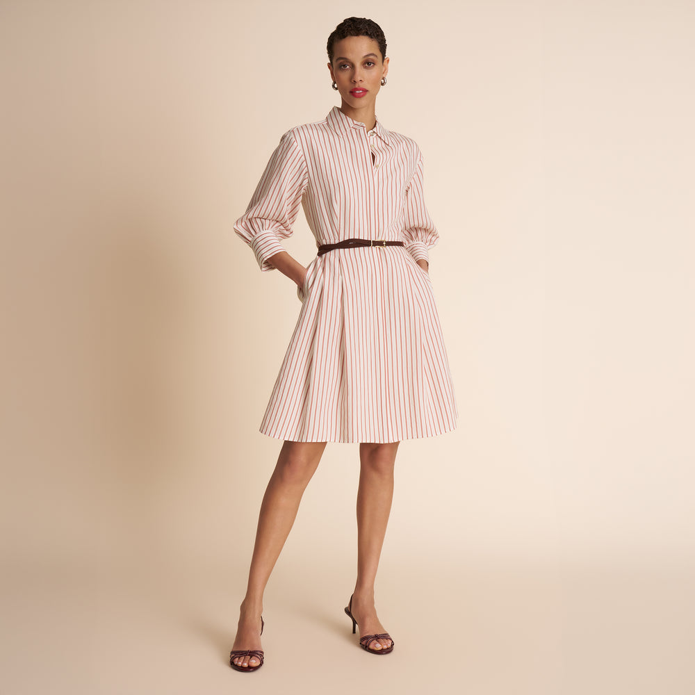 Woman wearing a striped dress on a beige background