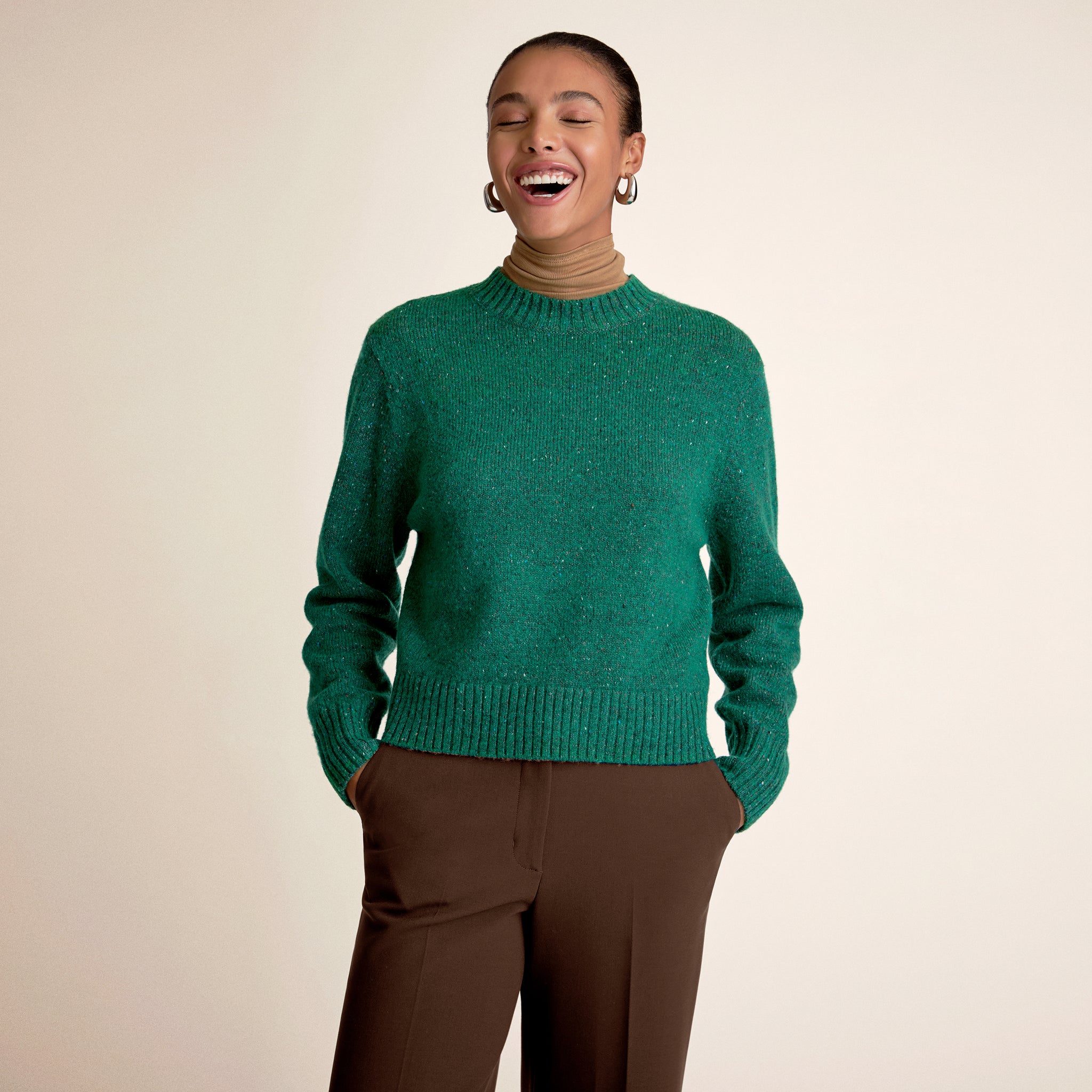 Woman wearing a green sweater with brown pants 