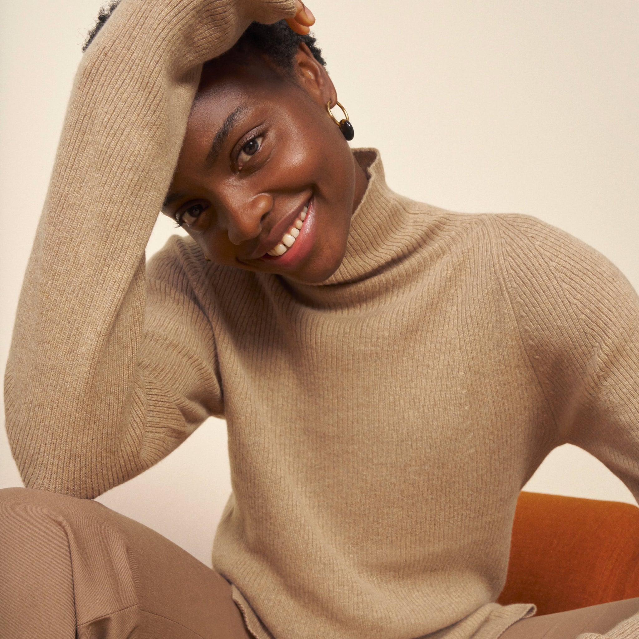 front image of a woman wearing the mckenzie sweater in deep flax
