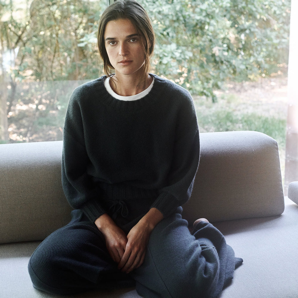 Person sitting on a couch with a blurred outdoor background