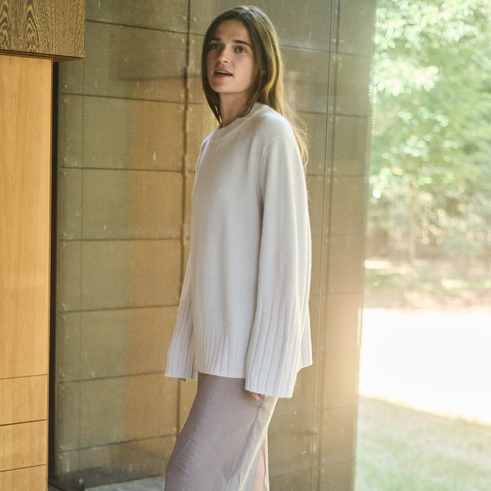Woman standing in front of a glass door with a blurred outdoor background