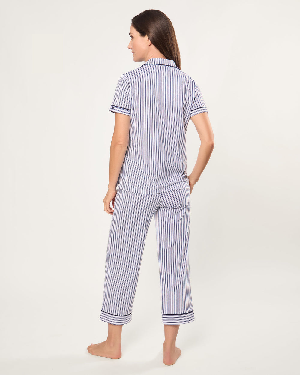 Woman wearing a blue and white striped pajama set on a white background