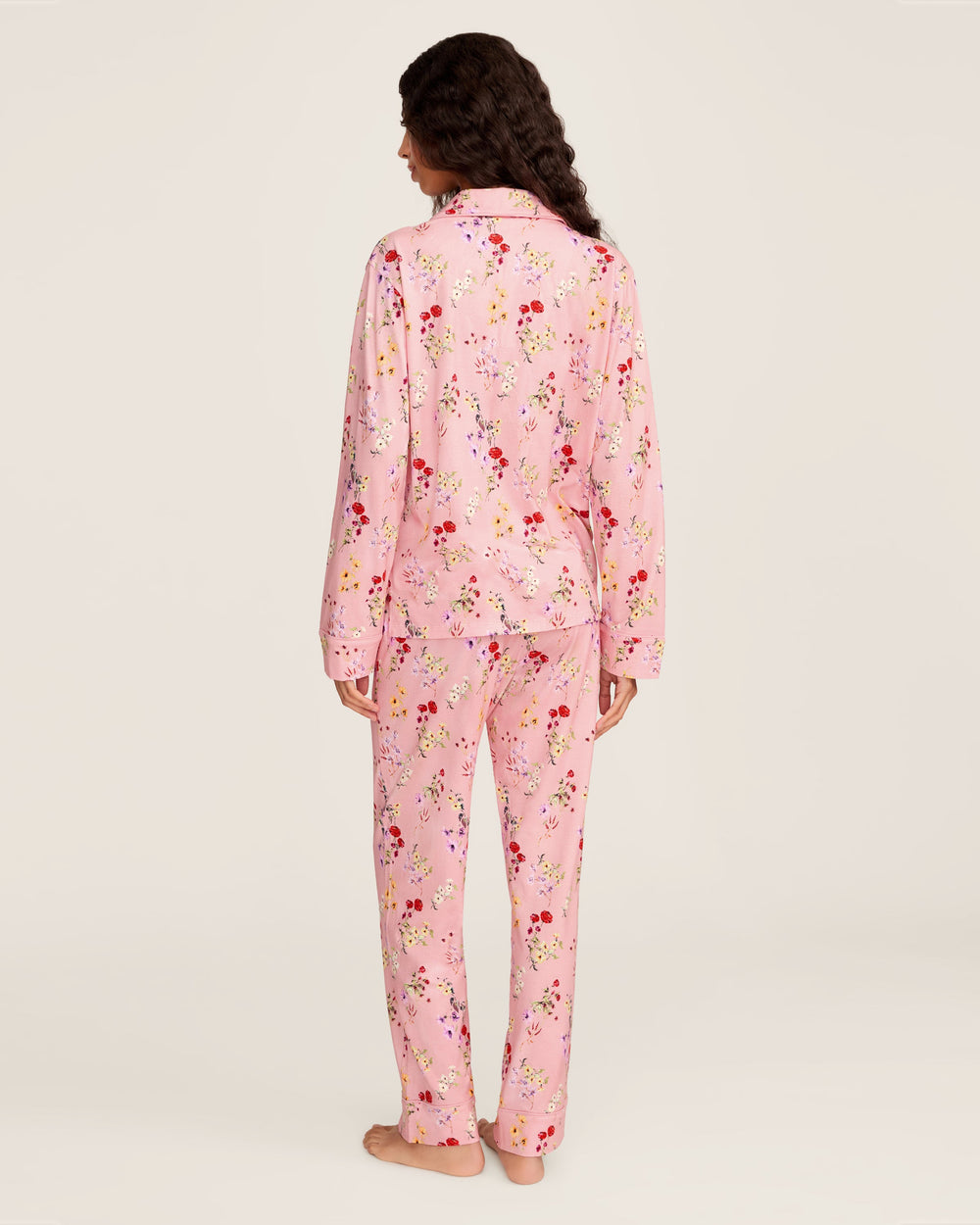 Person wearing pink floral pajamas on a plain background