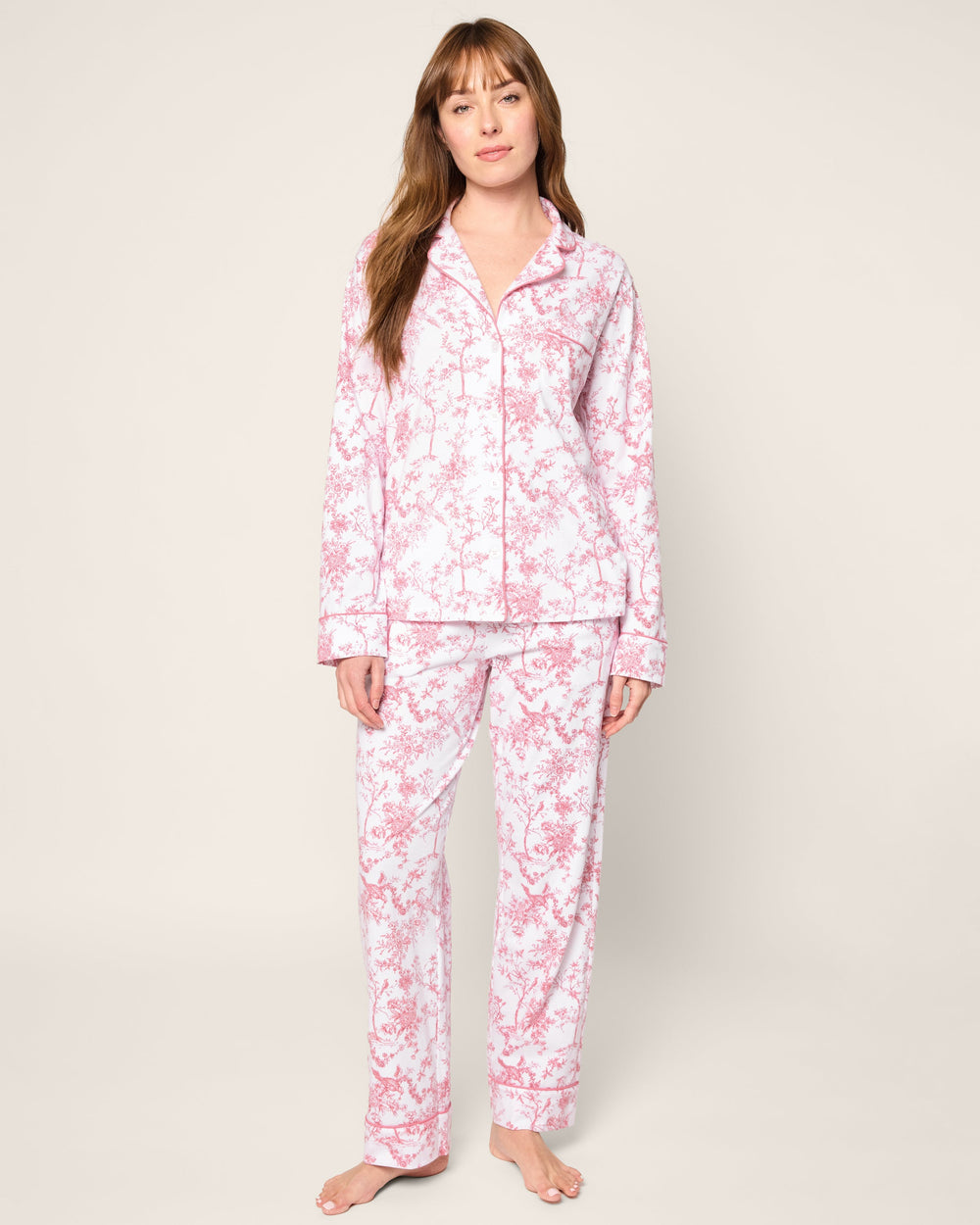 Woman wearing a pink floral pajama set on a white background