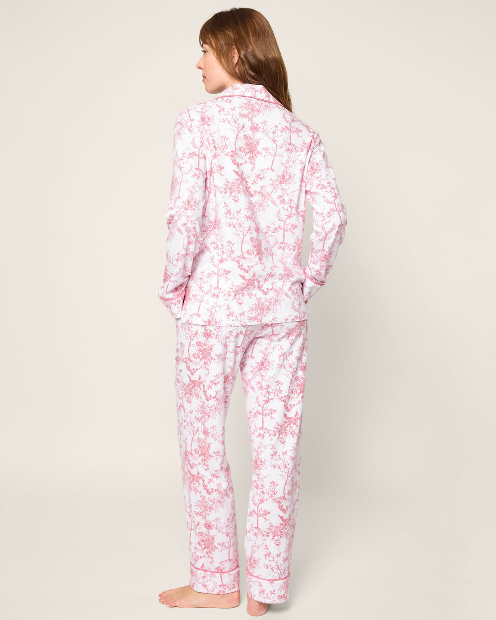 Person wearing pink floral pajamas on a plain background