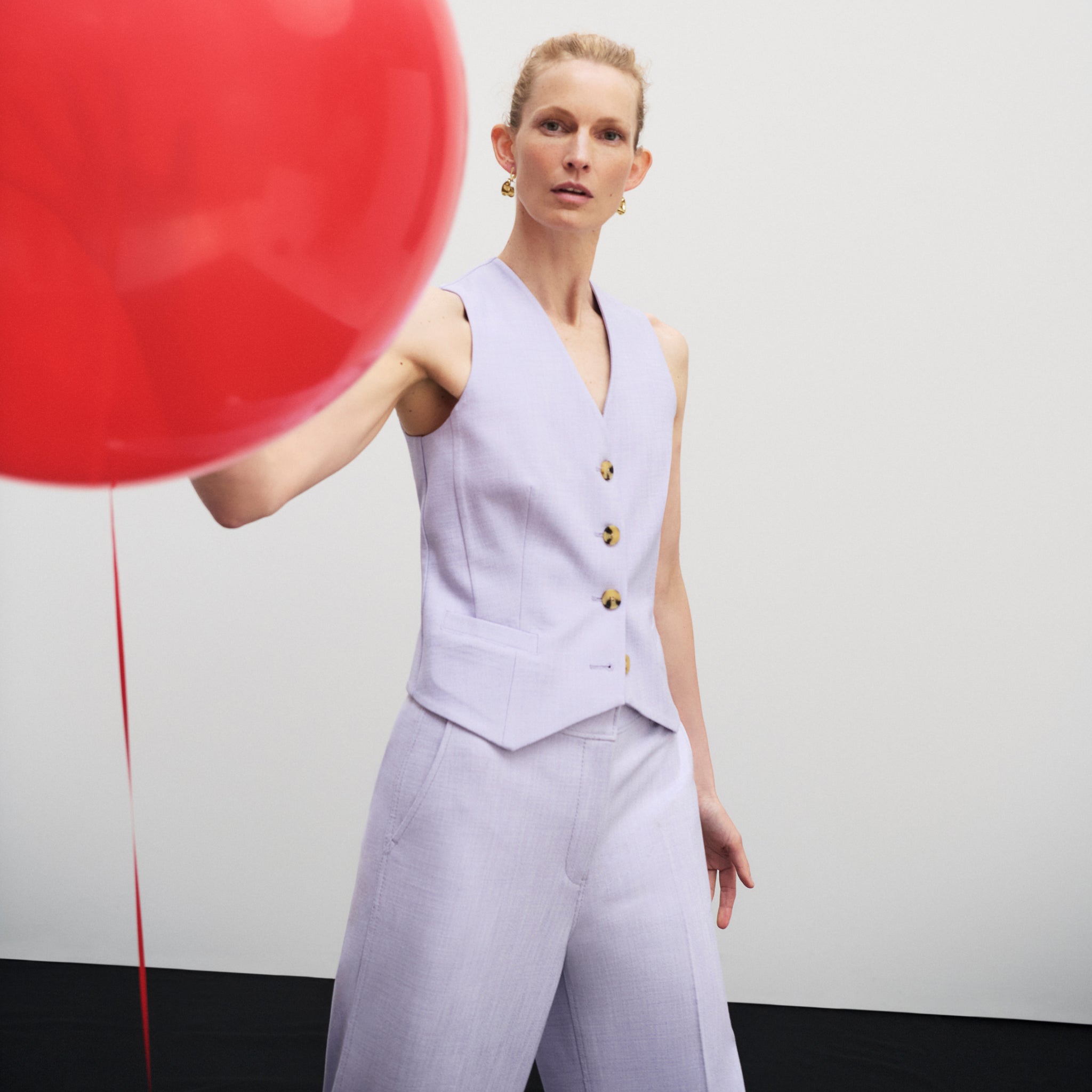 front image of a woman wearing the roo vest in lilac/ivory