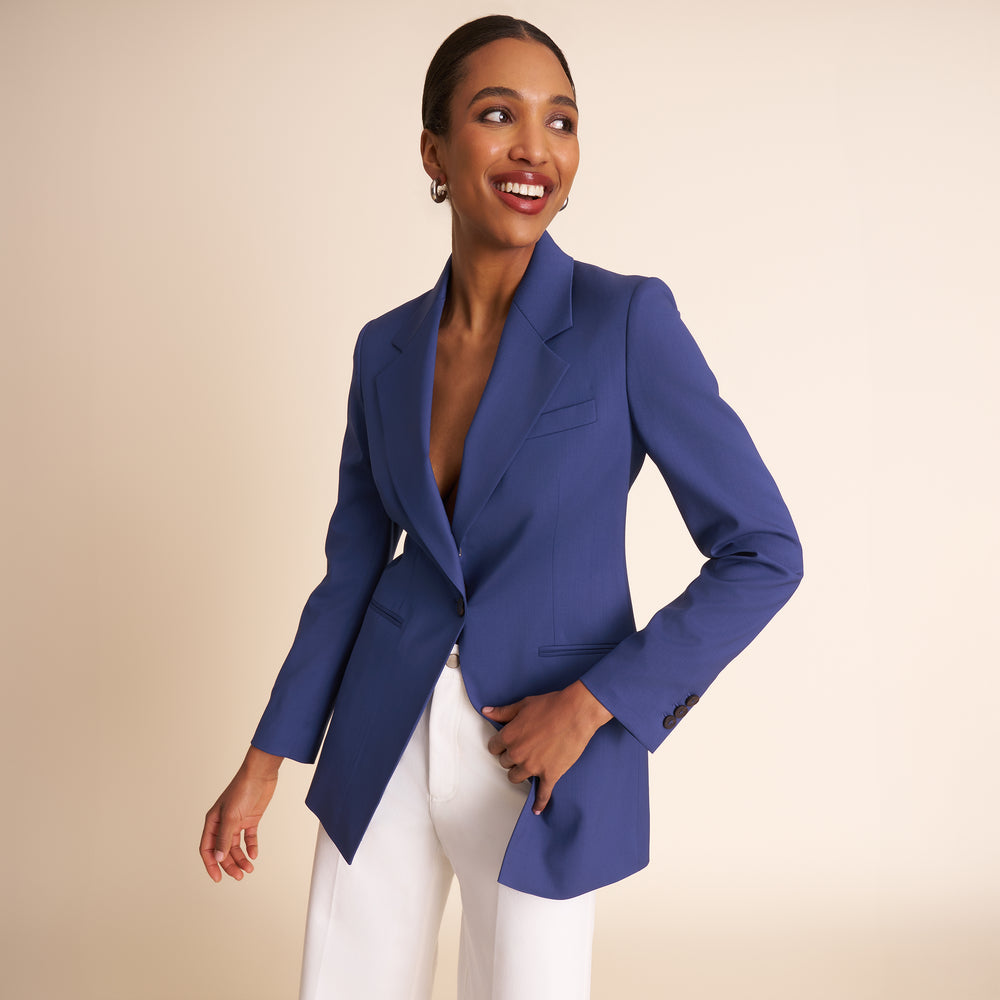 Woman wearing a blue suit with a white top on a beige background