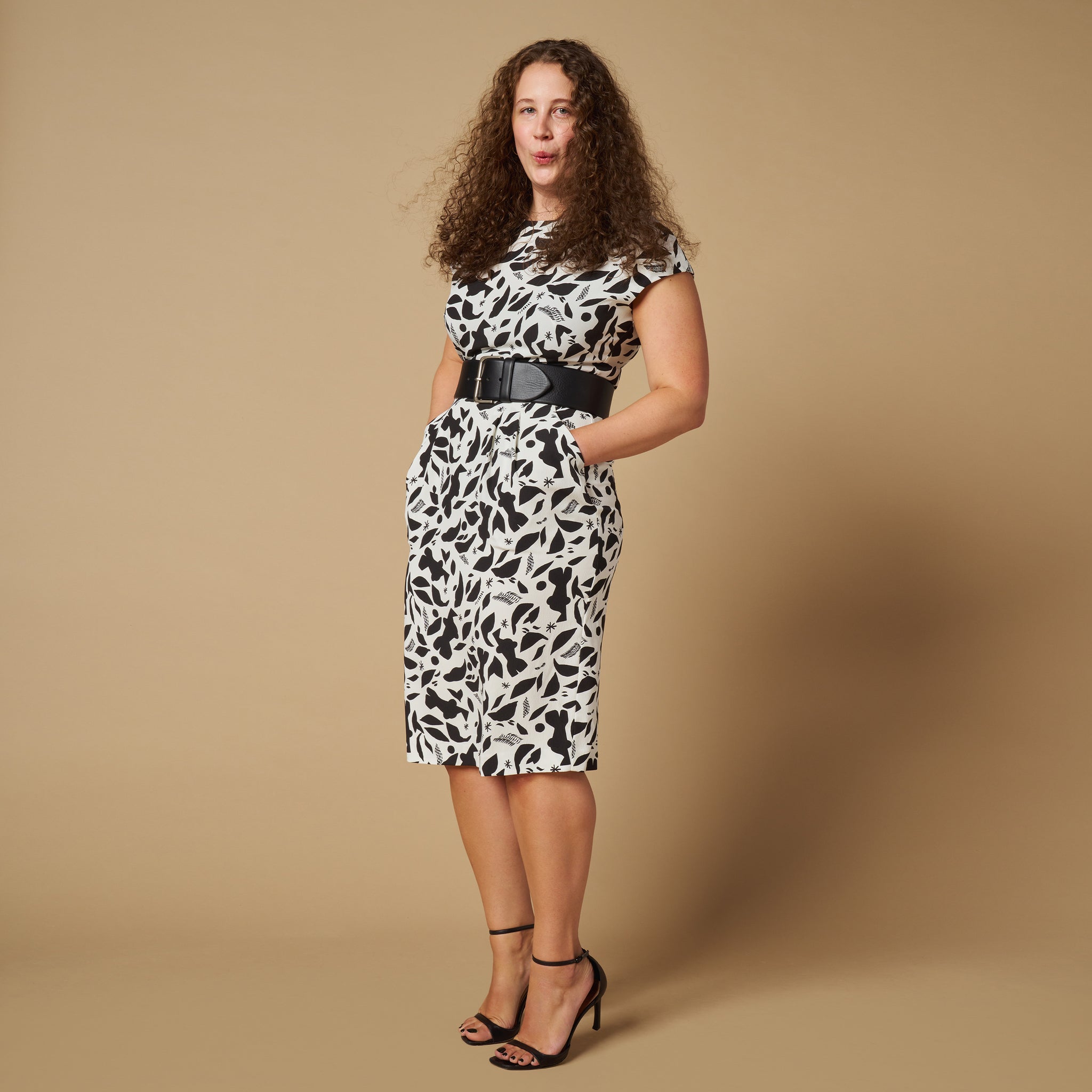front image of a woman wearing the masha dress in icon print with the beebe belt in black