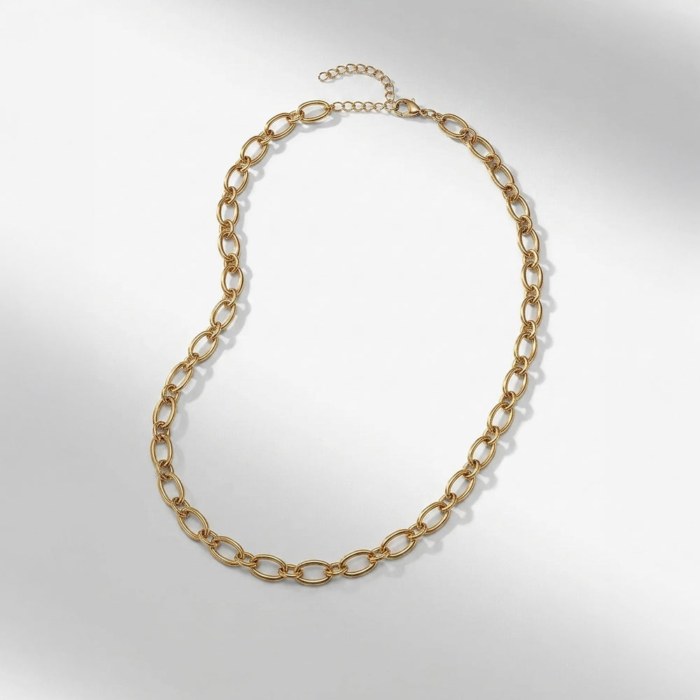 A gold chain necklace with elongated oval links and a short extender chain with a clasp, displayed on a light gray background.