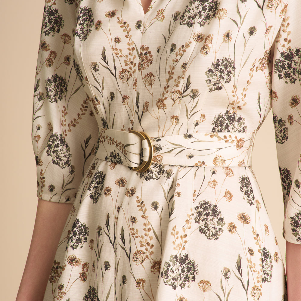 Floral patterned dress with a belt on a beige background