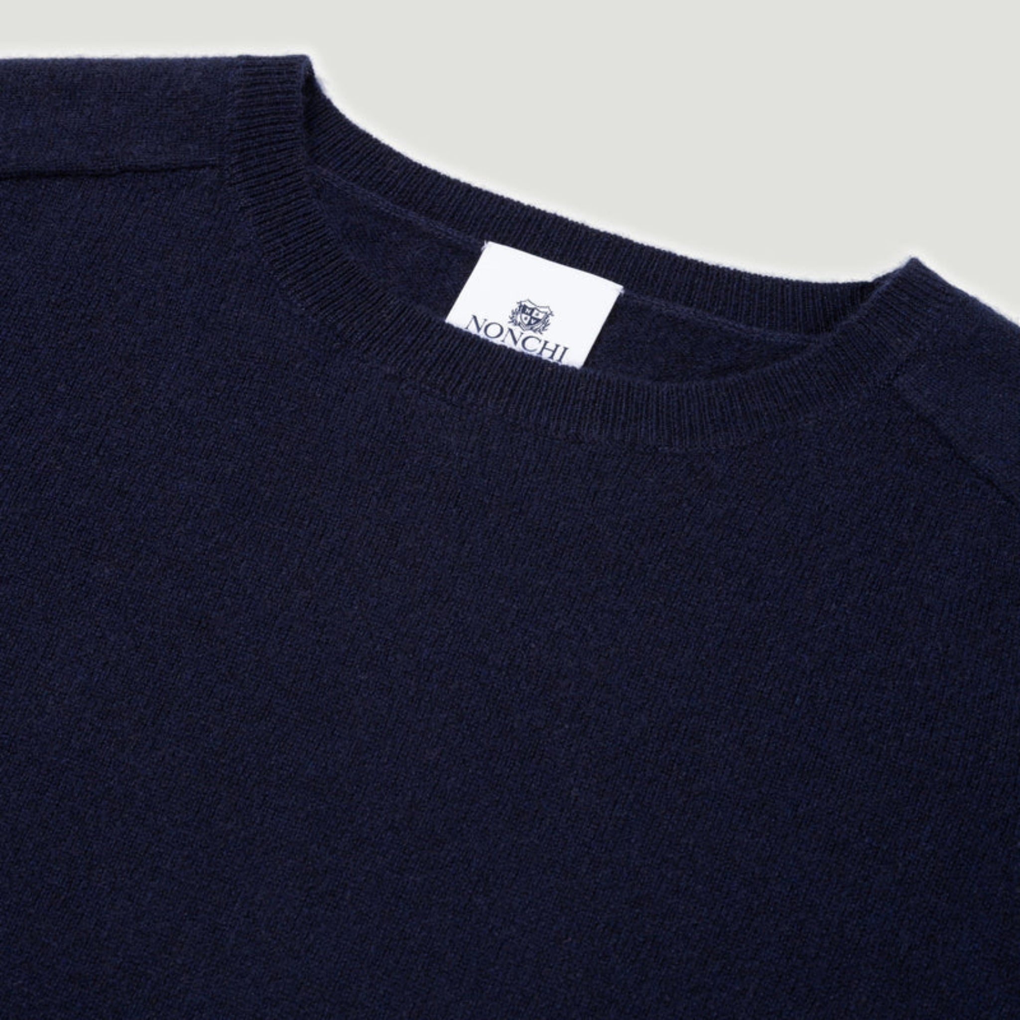 Navy sweater with a visible brand label on a light gray background