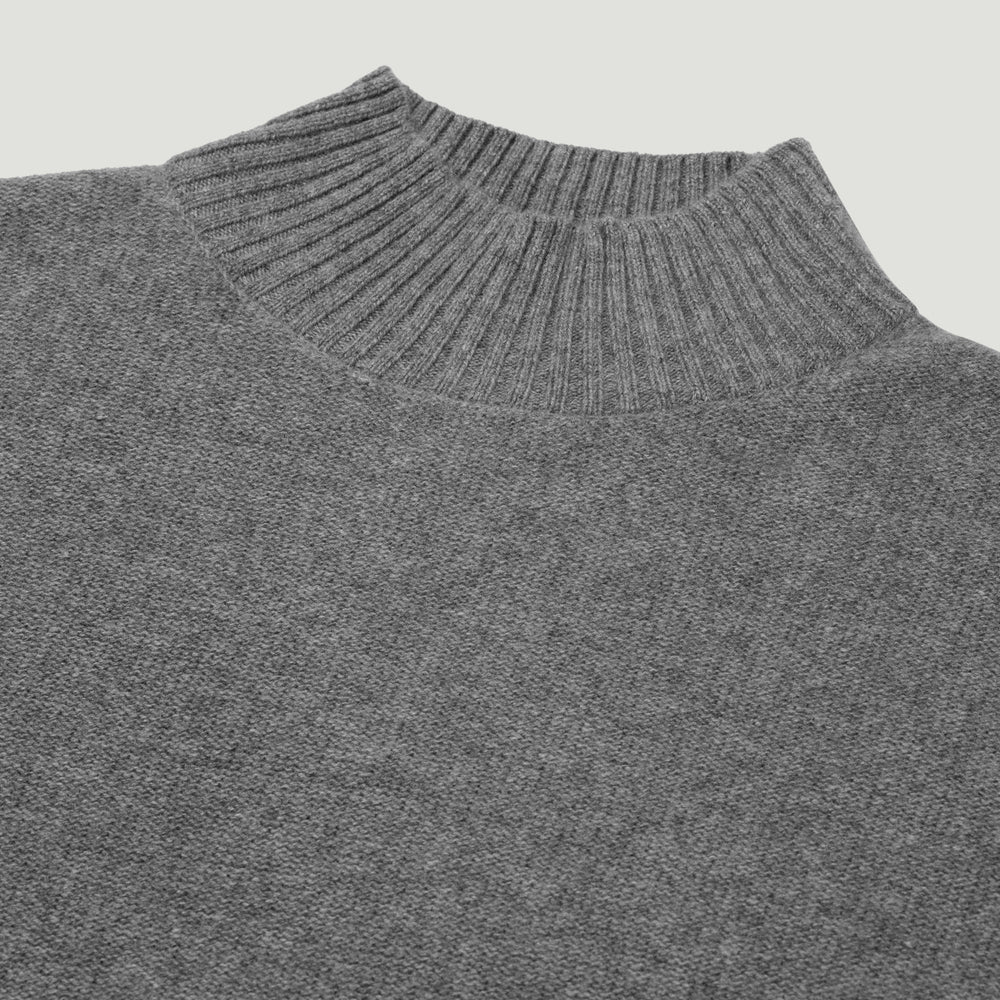 Close-up of a gray sweater with a ribbed neckline on a light gray background