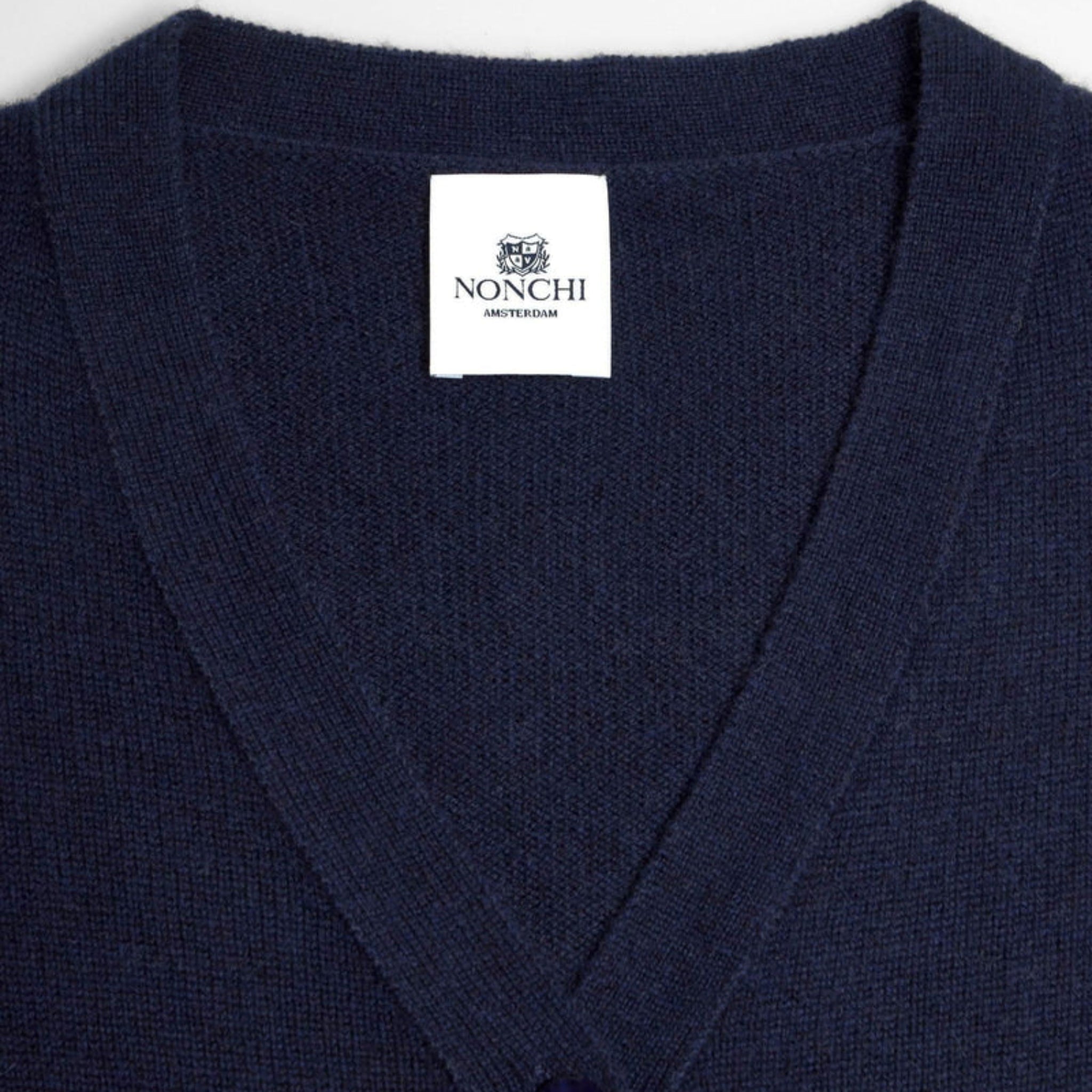 Navy blue cardigan with a Nonchi label on a white background