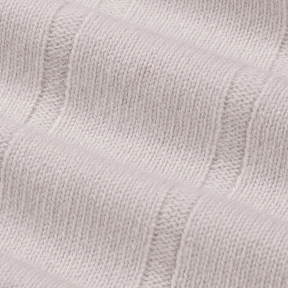 Close-up of a textured light gray fabric with a subtle pattern.