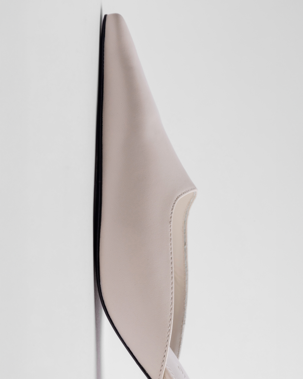 Beige sandal with a black sole on a white background