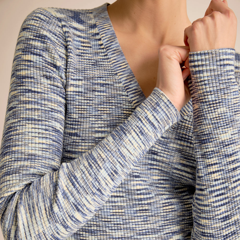 Close-up of a person wearing a blue and white checkered long-sleeve shirt.