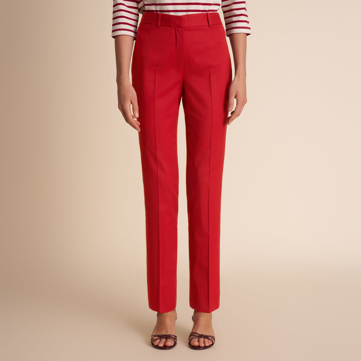 Red pants worn by a person on a beige background | Lead