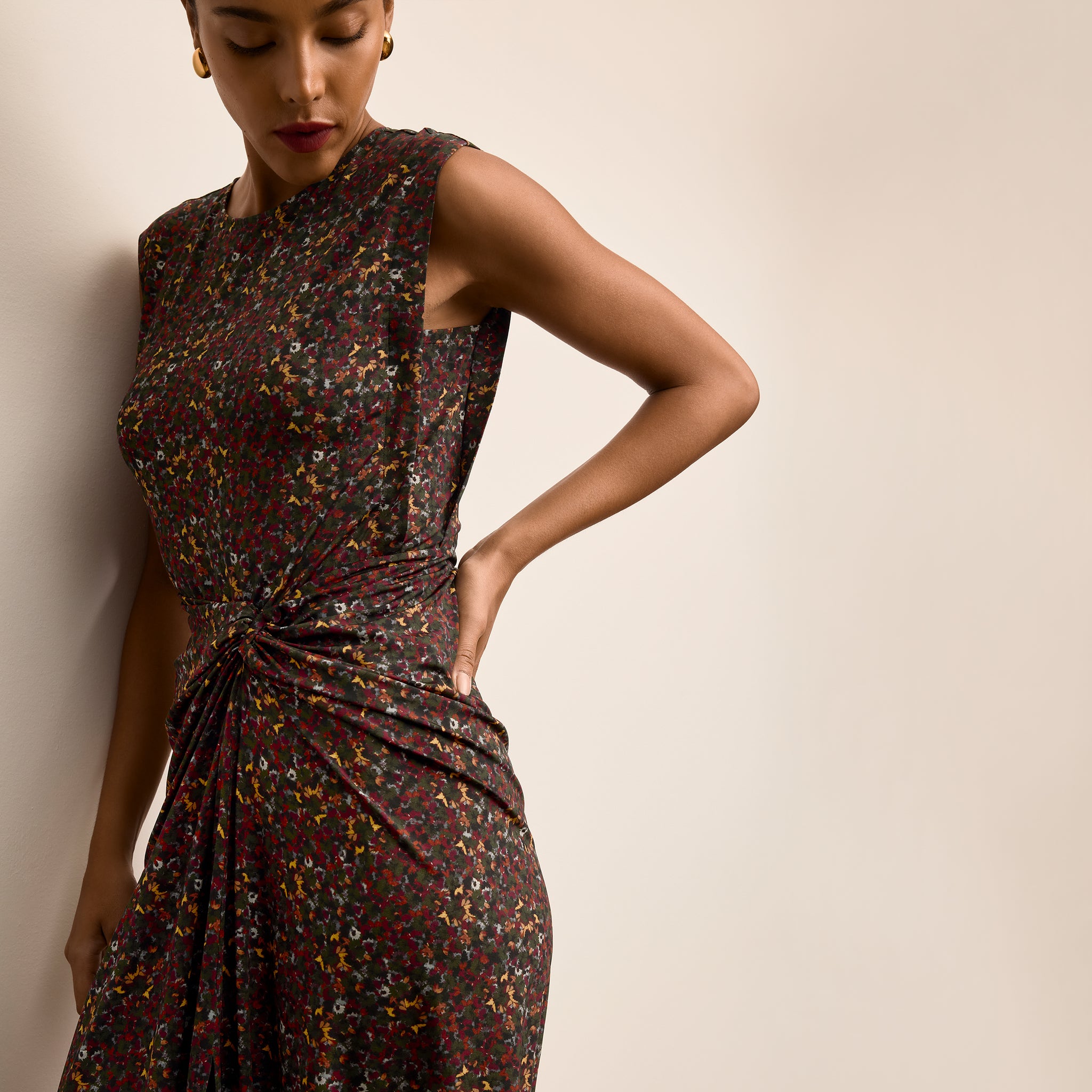 Woman wearing a patterned dress against a plain background