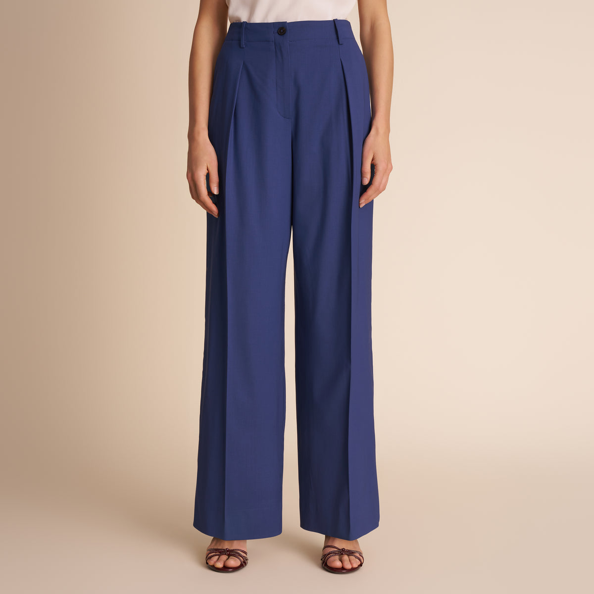 Blue pants worn by a person on a beige background