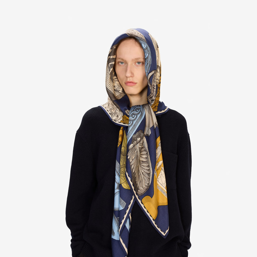 Person wearing a patterned scarf on a white background