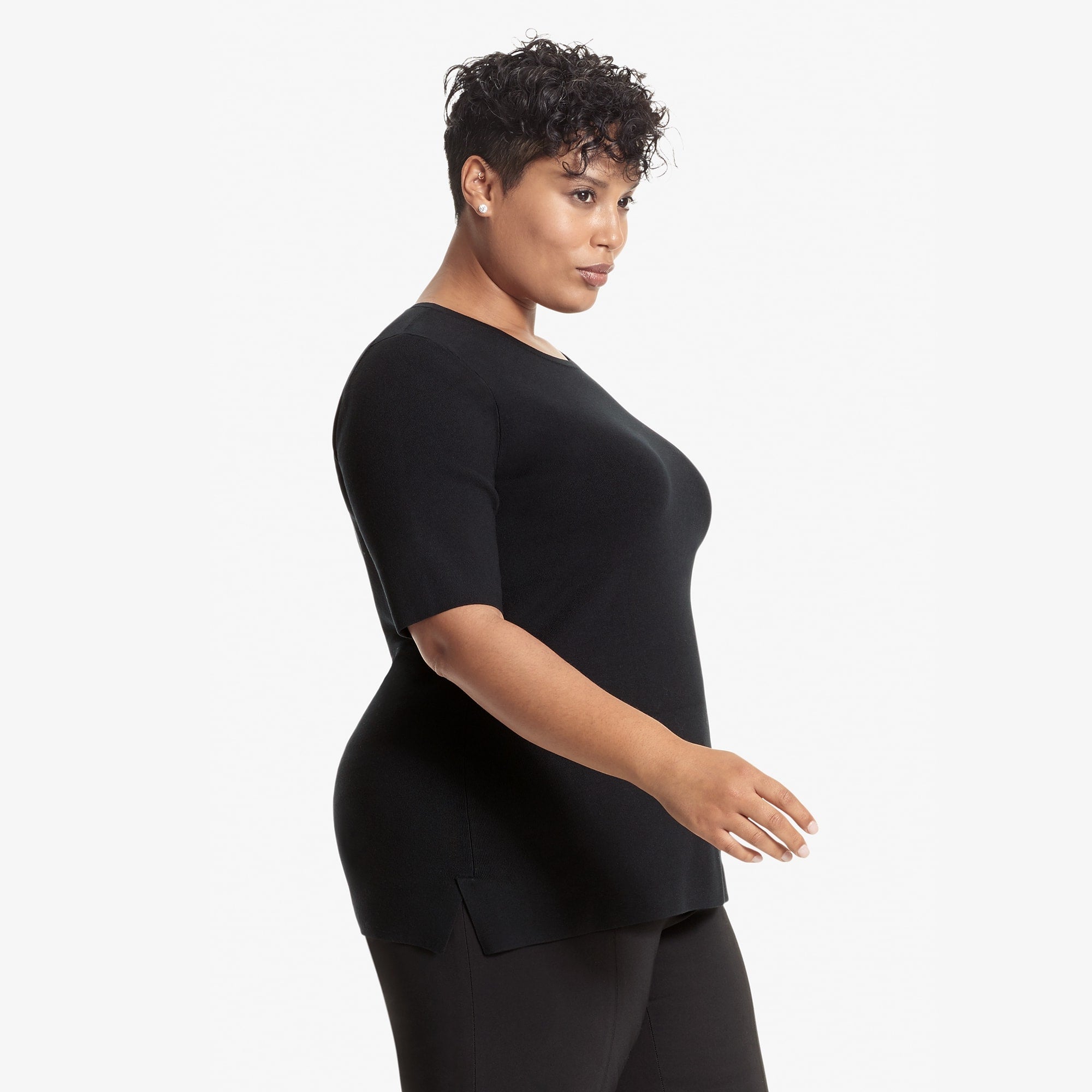 Side image of a woman standing wearing the Choe Top in Black