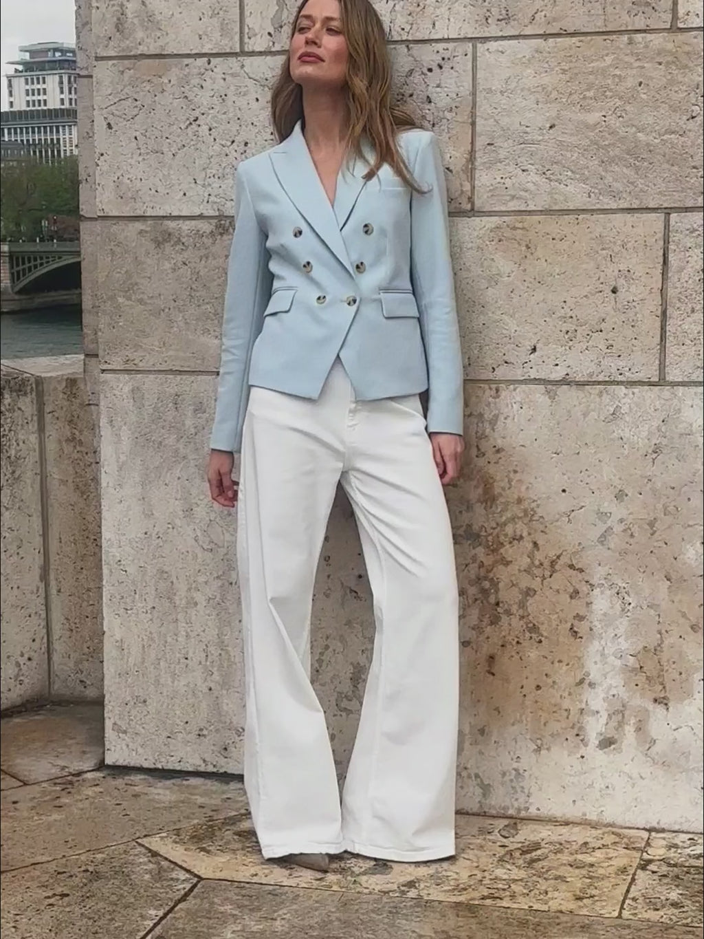 woman in light blue blazer with white pants