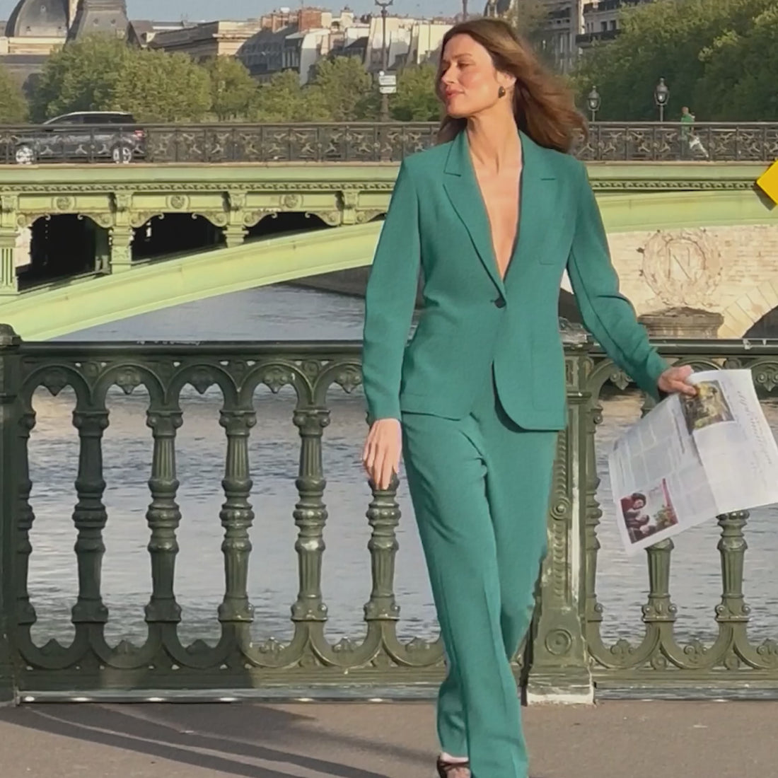 video of a woman reading the paper in a teal suit
