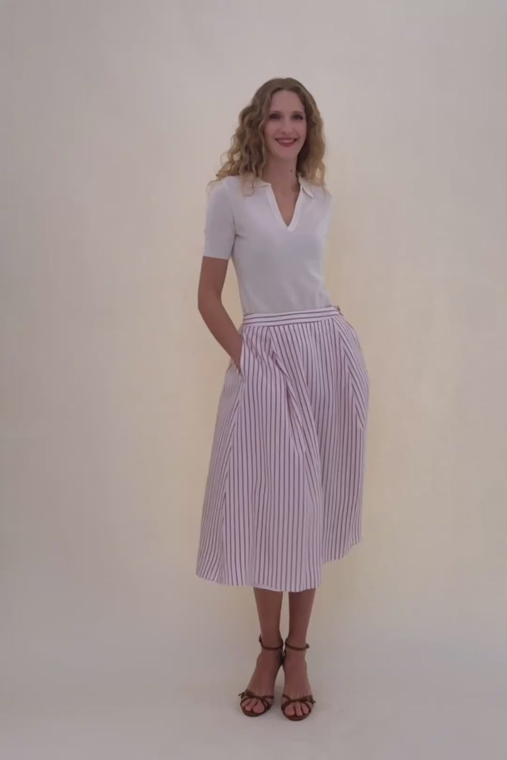 woman in white polo with stripped skirt.
