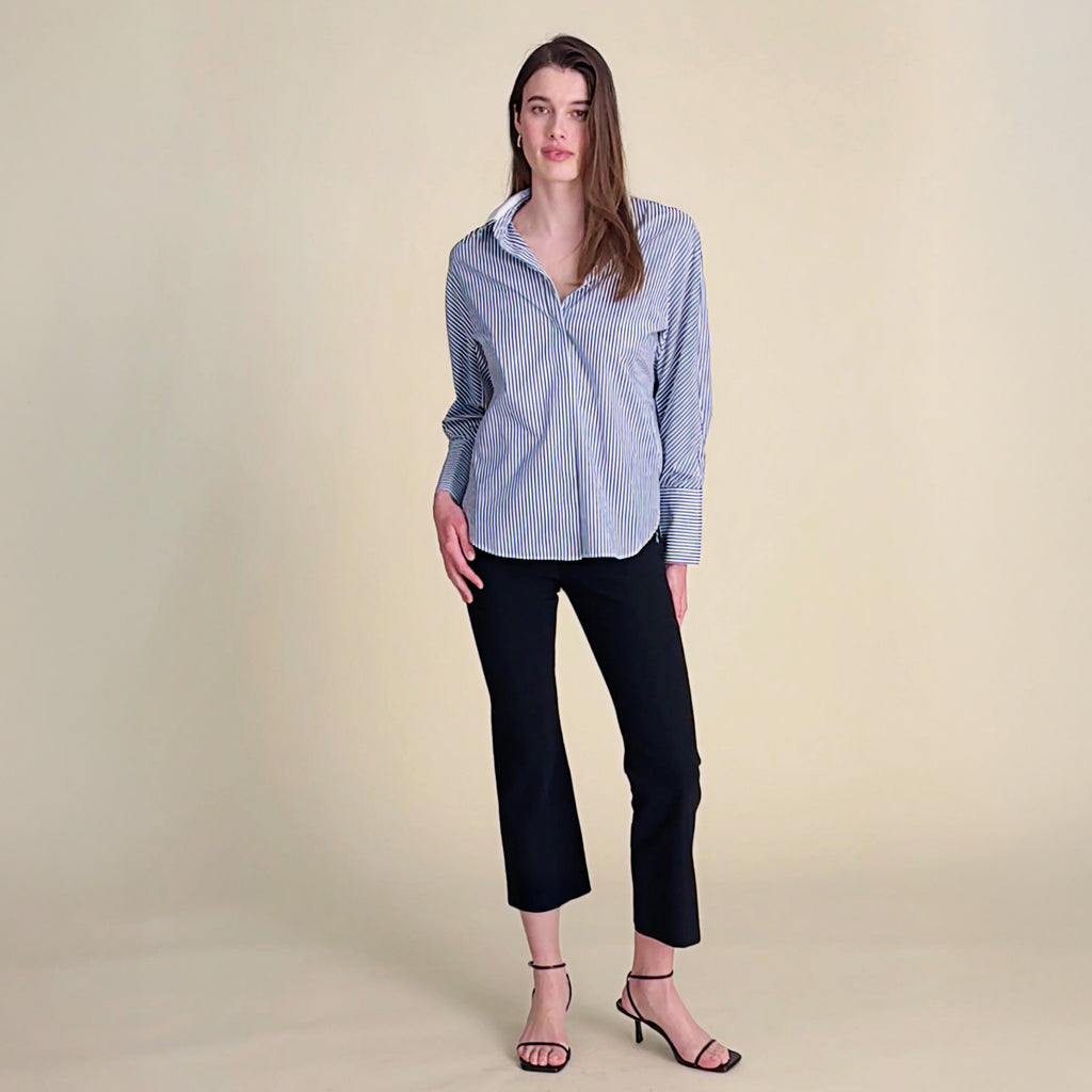 woman in striped button down with black pants.