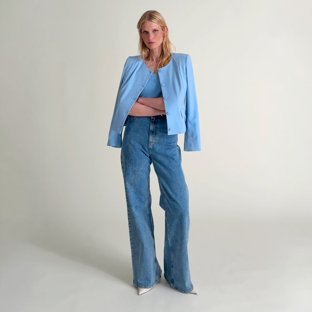 Woman wearing the Aniya jacket in clear sky, the paige tank in clear sky, and jeans