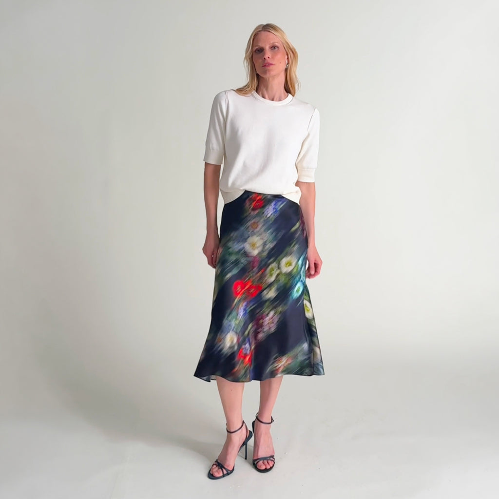 Woman wearing the iroha top in ivory and orchard skirt in garden haze