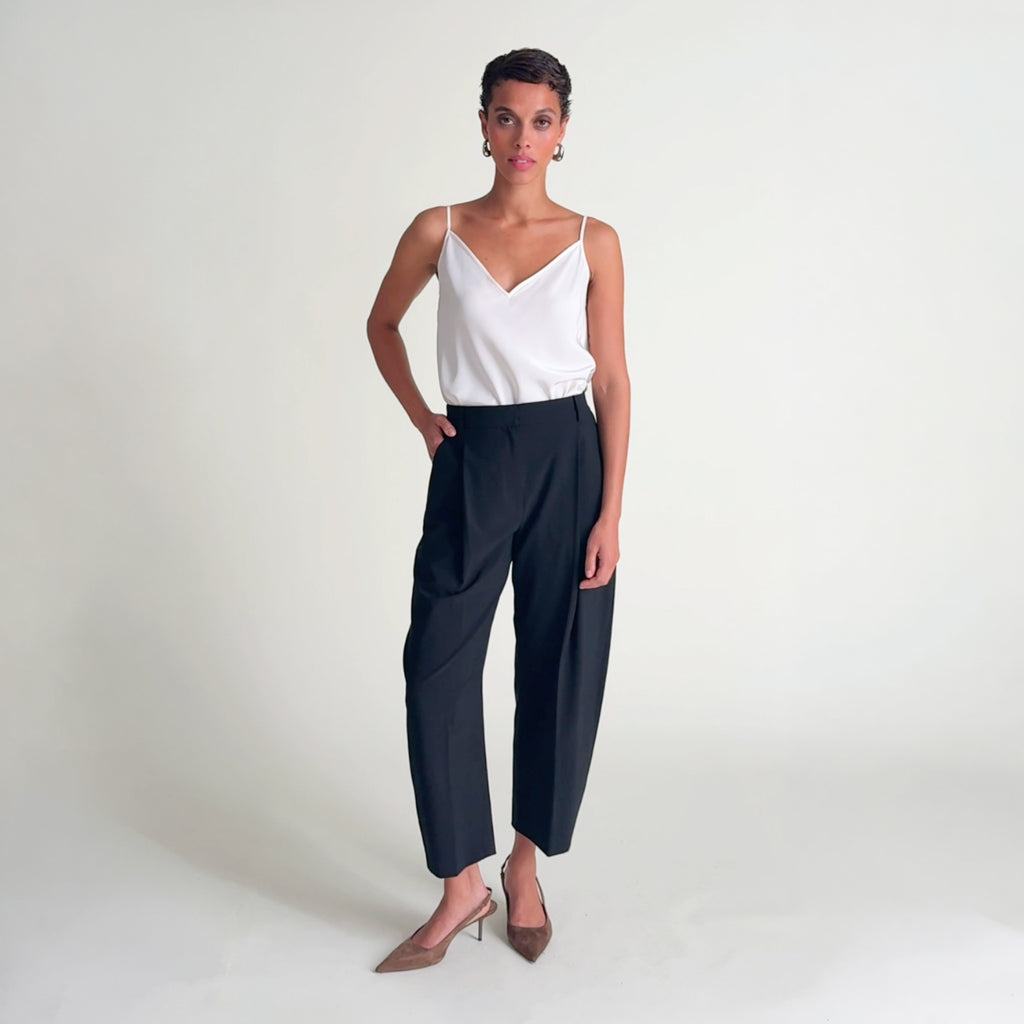 Woman wearing the lisey tank in ivory and bala pant black