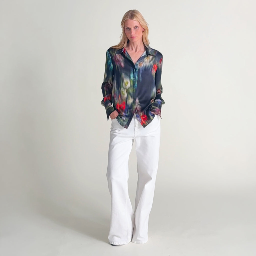 Woman wearing the tatum top in garden haze with white jeans