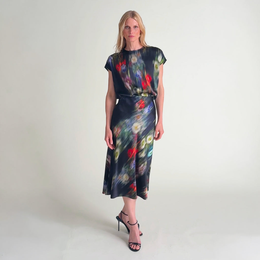 Woman wearing the didion top and orchard skirt in garden haze
