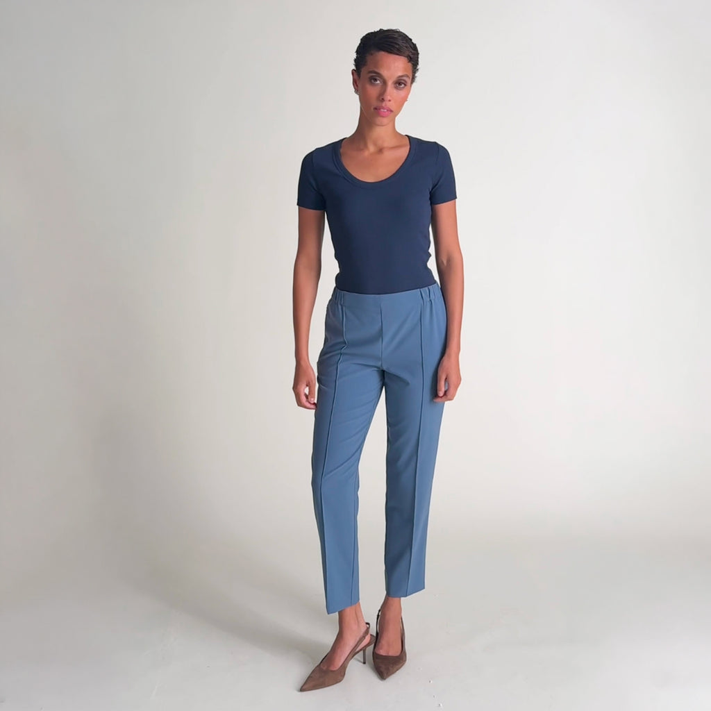 Woman wearing the avi top in oxford and colby pant in dusty blue