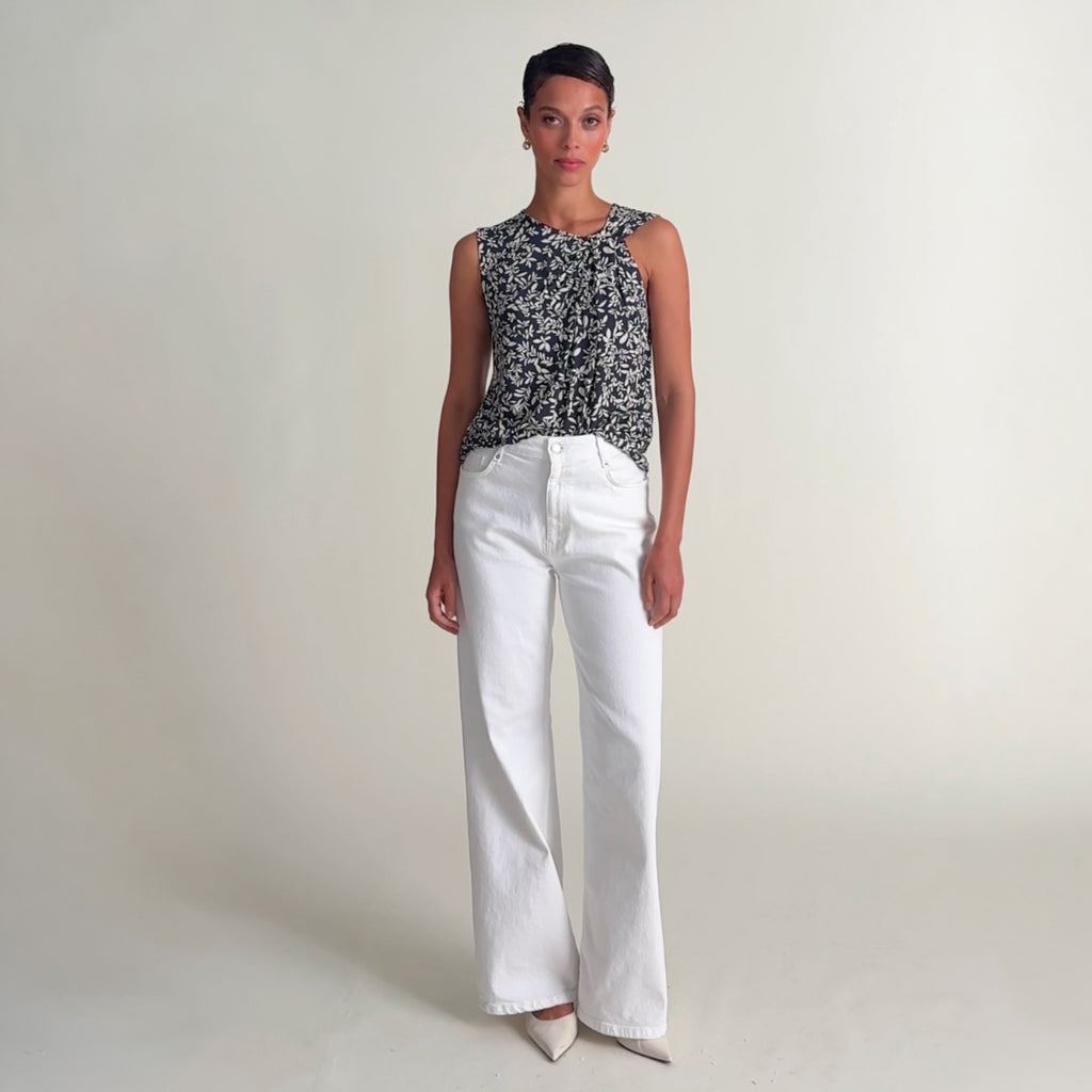 Woman wearing the hera top in leaf line fern and white jeans