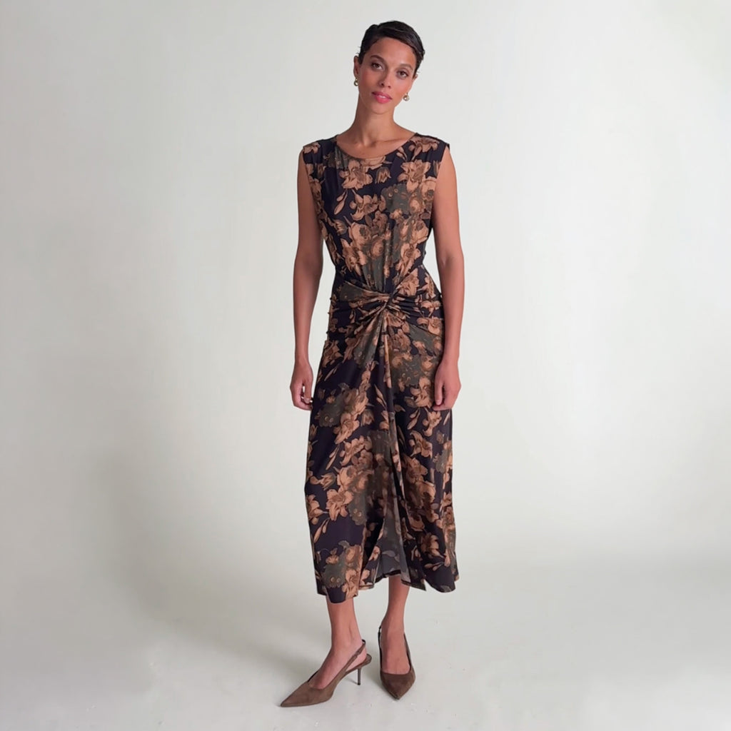 Woman wearing the Zita dress in gilded garden and showing the stretch of the dress.